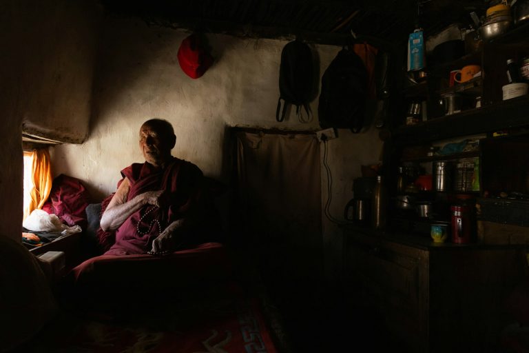 Monk sitting in a dimly lit room